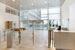 Moderne en lichte bedrijfsentree aan de Tupolevlaan met receptiebalie, draaipoortjes en glazen ingang.