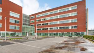 Modern kantoorgebouw aan de Tupolevlaan met roodbruine gevel en glazen entree.