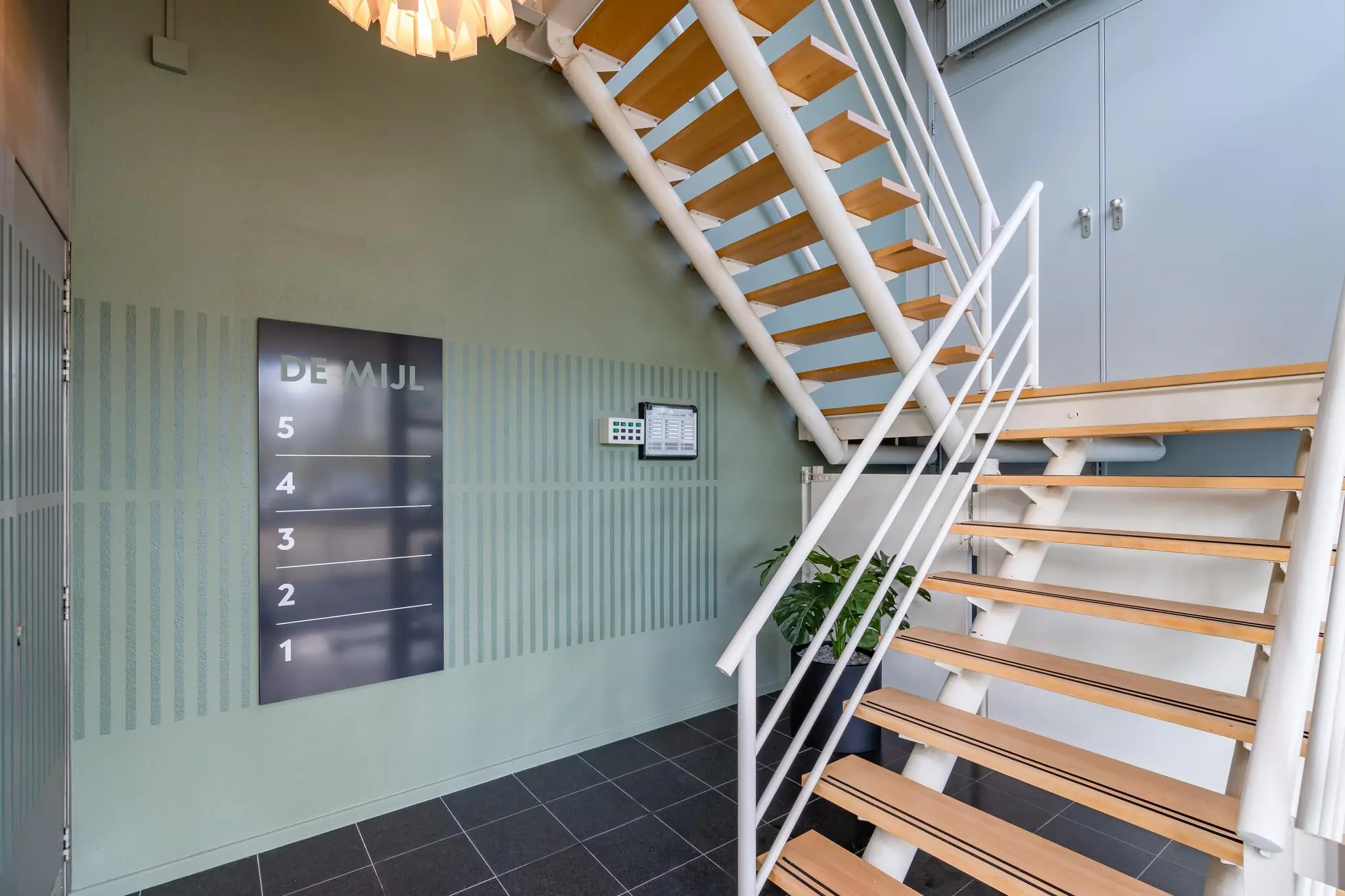 Trapopgang en entreehal met bedrijfsnaambord "De Mijl" en toegangspaneel aan de muur.