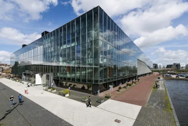 Modern glazen kantoorgebouw aan de Jacob Bontiusplaats in Amsterdam, gelegen naast het water.