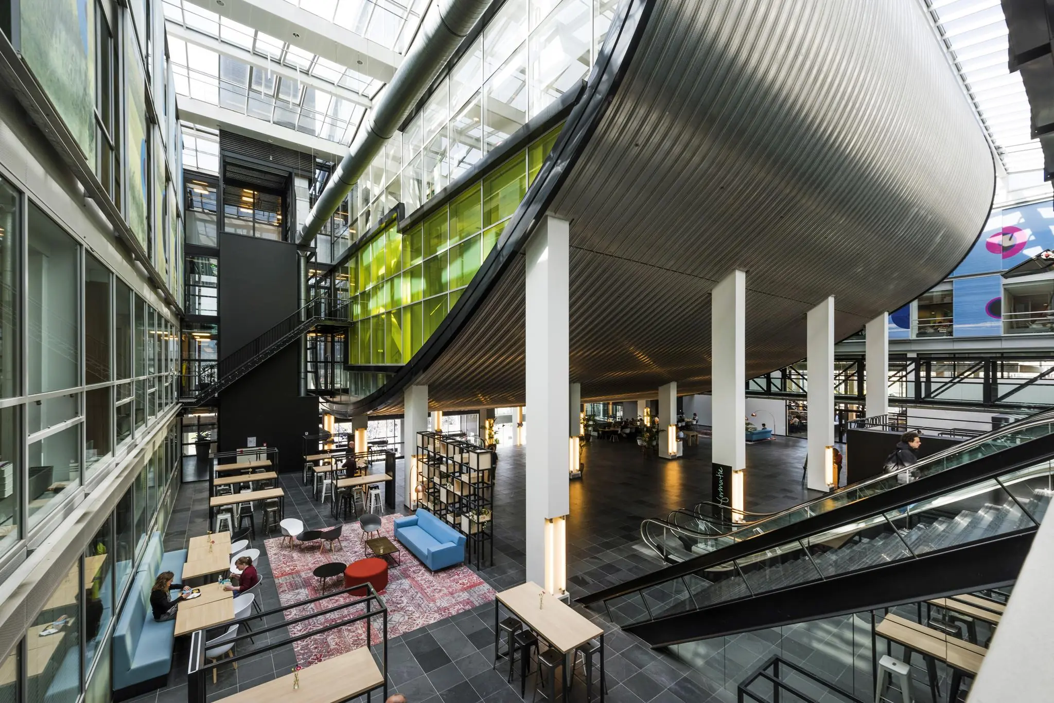 Moderne, open binnentuin met zitplekken en opvallende architectuur in het gebouw aan de Jacob Bontiusplaats.