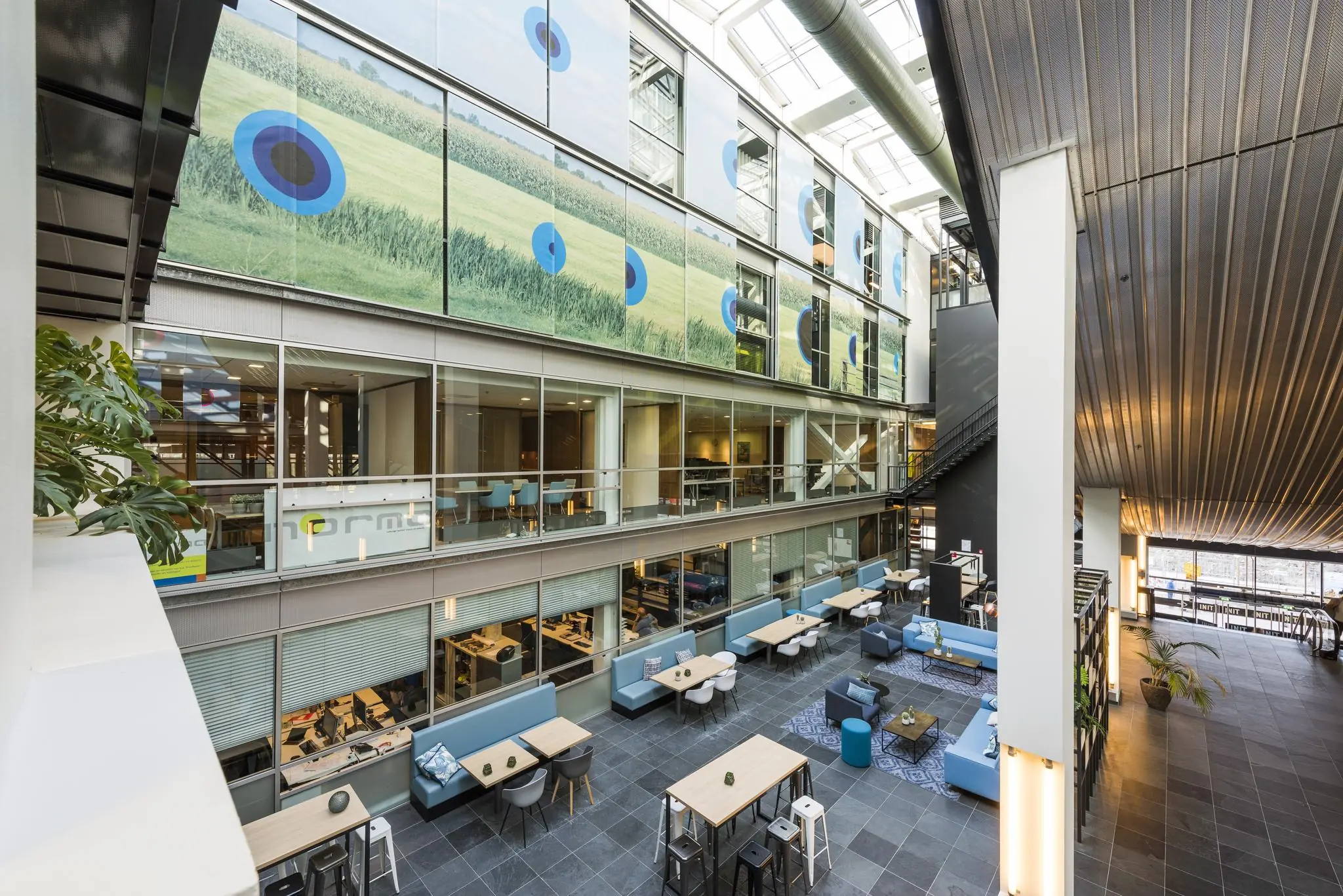 Moderne, open kantoorruimte aan de Jacob Bontiusplaats met zitplekken, glazen wanden en kunst aan de gevel.