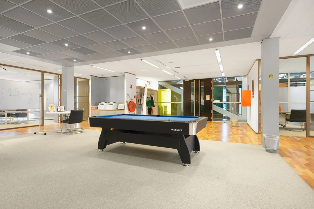 Moderne kantoorruimte aan de Jacob Bontiusplaats met een pooltafel in het midden van een open werkgebied.