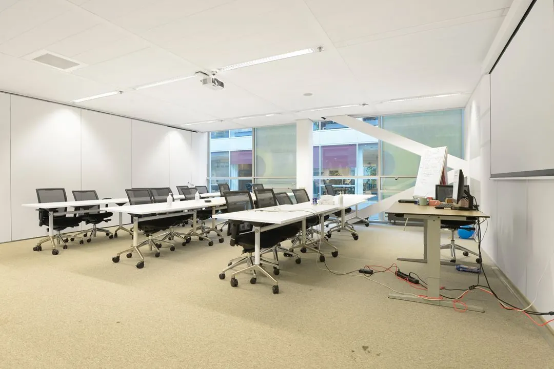 Moderne vergaderruimte op de Jacob Bontiusplaats met opgestelde tafels, stoelen, een projector en presentatiemateriaal.
