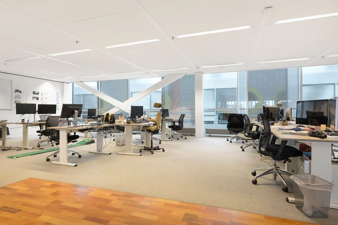 Moderne, open kantoorruimte aan de Jacob Bontiusplaats met meerdere werkplekken, bureaustoelen en computers.