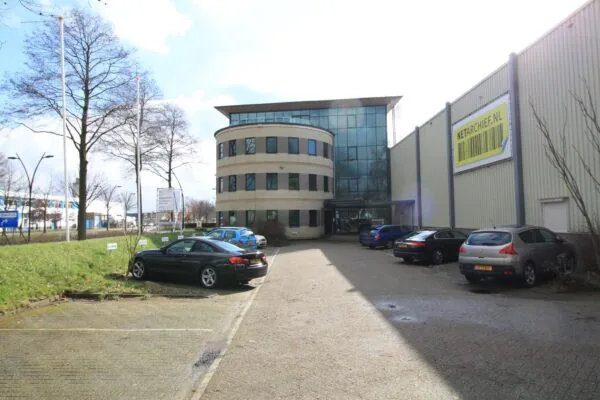 Kantoor- en bedrijfsgebouw aan de Koningsweg met parkeerplaatsen en Netarchive.nl-banner op de gevel.
