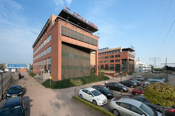 Kantoorpand van ICT Optima Forma aan de Zonnebaan met parkeergelegenheid op de voorgrond.