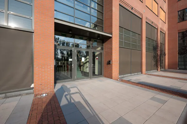 Ingang van een modern kantoorgebouw aan de Zonnebaan met rode bakstenen en glazen deuren.