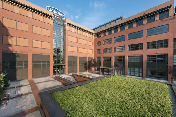 Binnenplaats van het Danone-kantoorgebouw aan de Zonnebaan, met rode baksteen, grote ramen en een groene binnentuin.