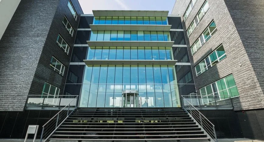 Modern kantoorgebouw aan het Stationspark met glazen façade en brede trappen aan de voorzijde.