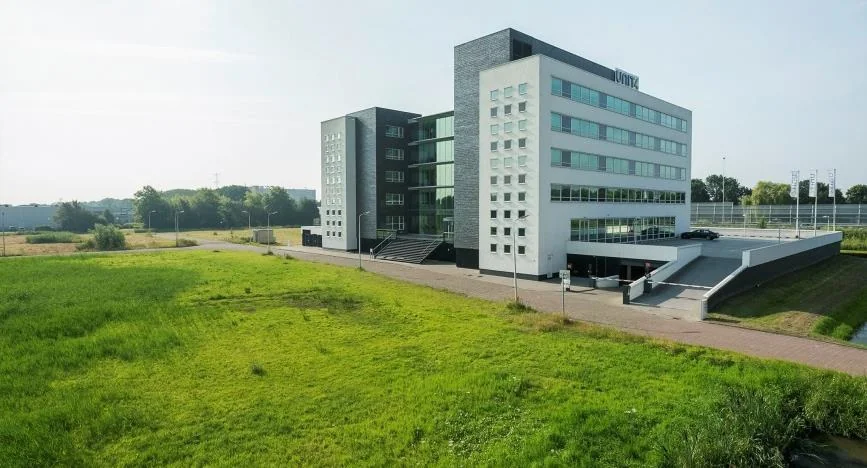Modern kantoorgebouw aan het Stationspark met ruime groenstrook op de voorgrond.
