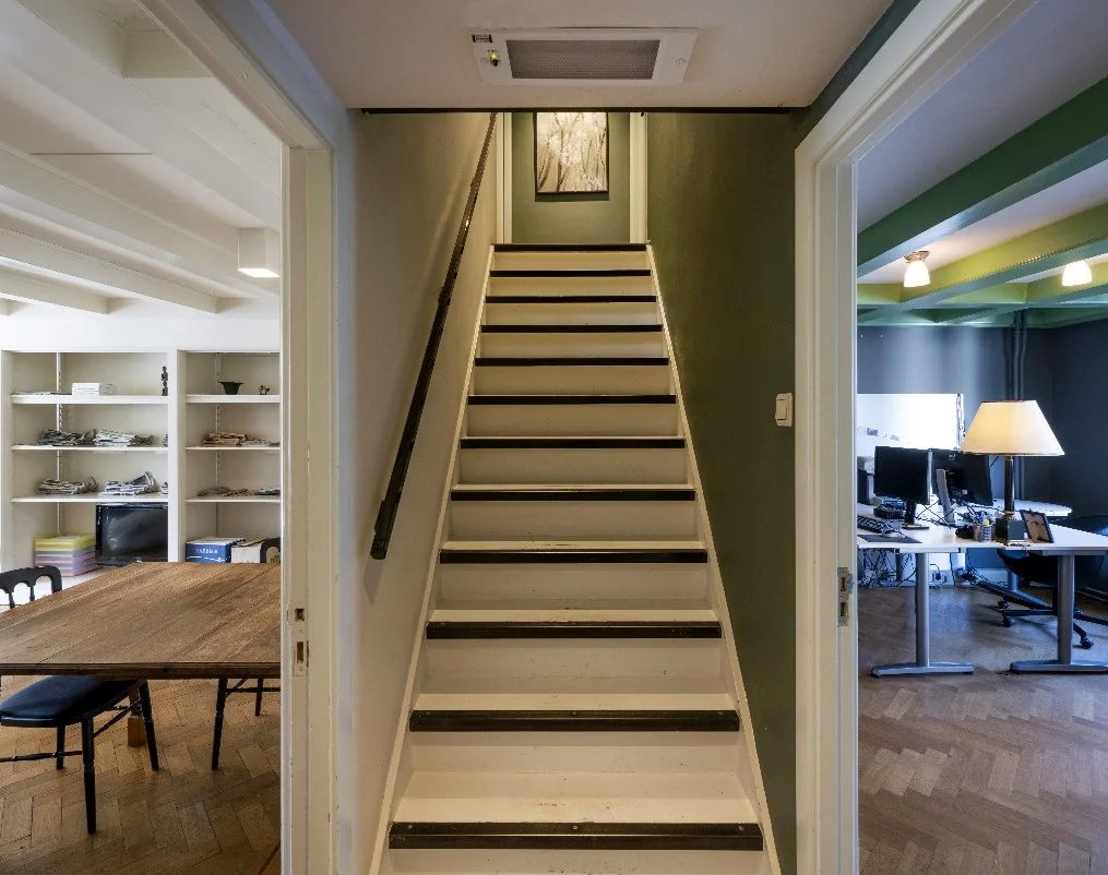 Trapopgang in een woning aan de Leidsegracht, met links een eetkamer en rechts een kantoorruimte.