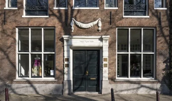 Voorgevel van een historisch pand aan de Leidsegracht in Amsterdam met grote ramen en een dubbele donkere voordeur.