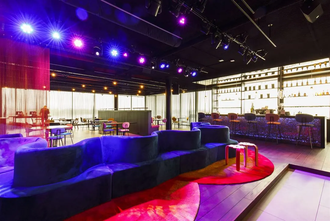 Modern ingerichte loungebar aan de Moermanskade met kleurrijke verlichting, designmeubels en een stijlvolle bar.
