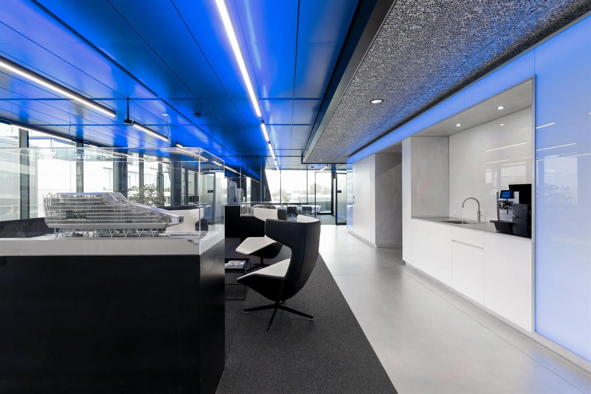 Modern kantoorinterieur aan de Moermanskkade met strakke meubels, blauwe verlichting en een architectonisch schaalmodel.