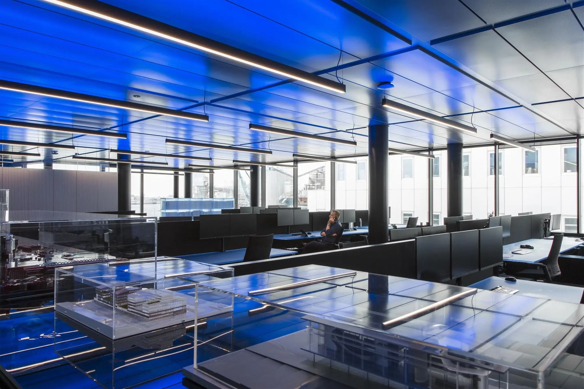 Modern kantoorinterieur aan de Moermanskade met blauwe verlichting en architectuurmodellen op de voorgrond.