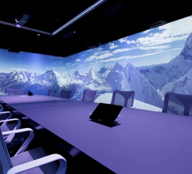 Vergaderruimte aan de Moermanskkade met een groot scherm waarop een panoramisch berglandschap wordt weergegeven.