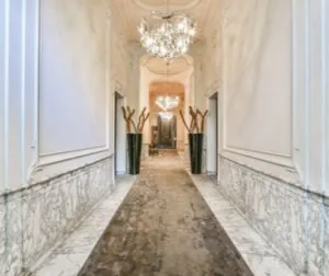Luxe marmeren gang in een grachtenpand aan de Herengracht met kroonluchters en moderne decoratie.