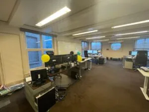 Kantoorruimte aan de Herengracht met meerdere werkplekken, computers en enkele gekleurde ballonnen.