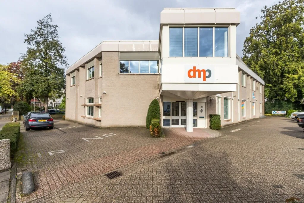Vooraanzicht van een kantoorpand aan de Utrechtseweg met dmp-logo boven de entree.