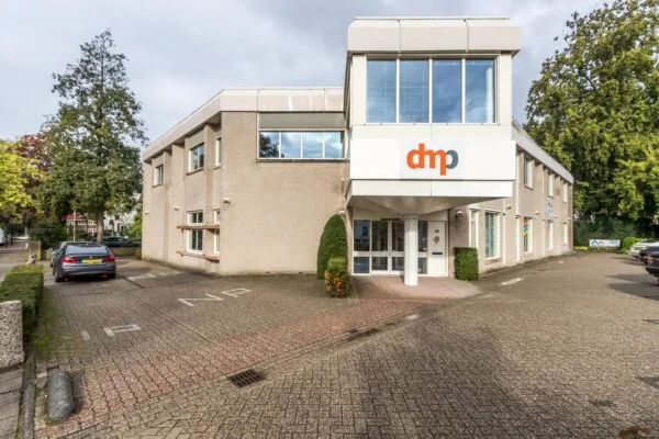 Vooraanzicht van een kantoorpand aan de Utrechtseweg met dmp-logo boven de entree.