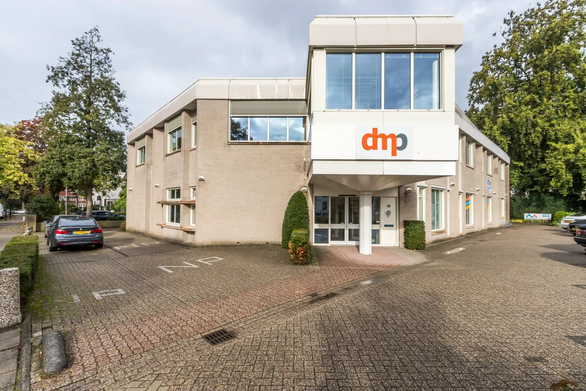 Vooraanzicht van een kantoorpand aan de Utrechtseweg met dmp-logo boven de entree.