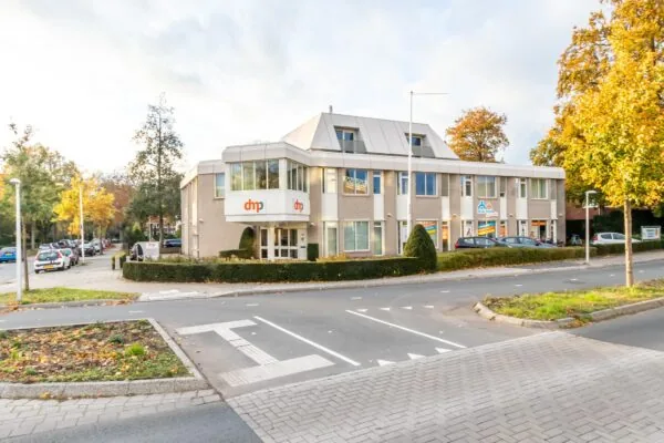 Kantoorpand aan de Utrechtseweg met bedrijfslogo’s van dmp en Maklam, gelegen op een hoek met een rotonde en omgeven door herfstkleurige bomen.