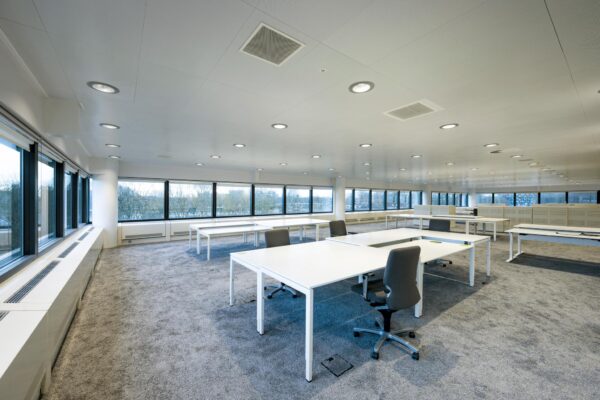 Ruim en modern kantoorinterieur aan de Prof. E.M. Meijerslaan met grote ramen en witte bureaus.