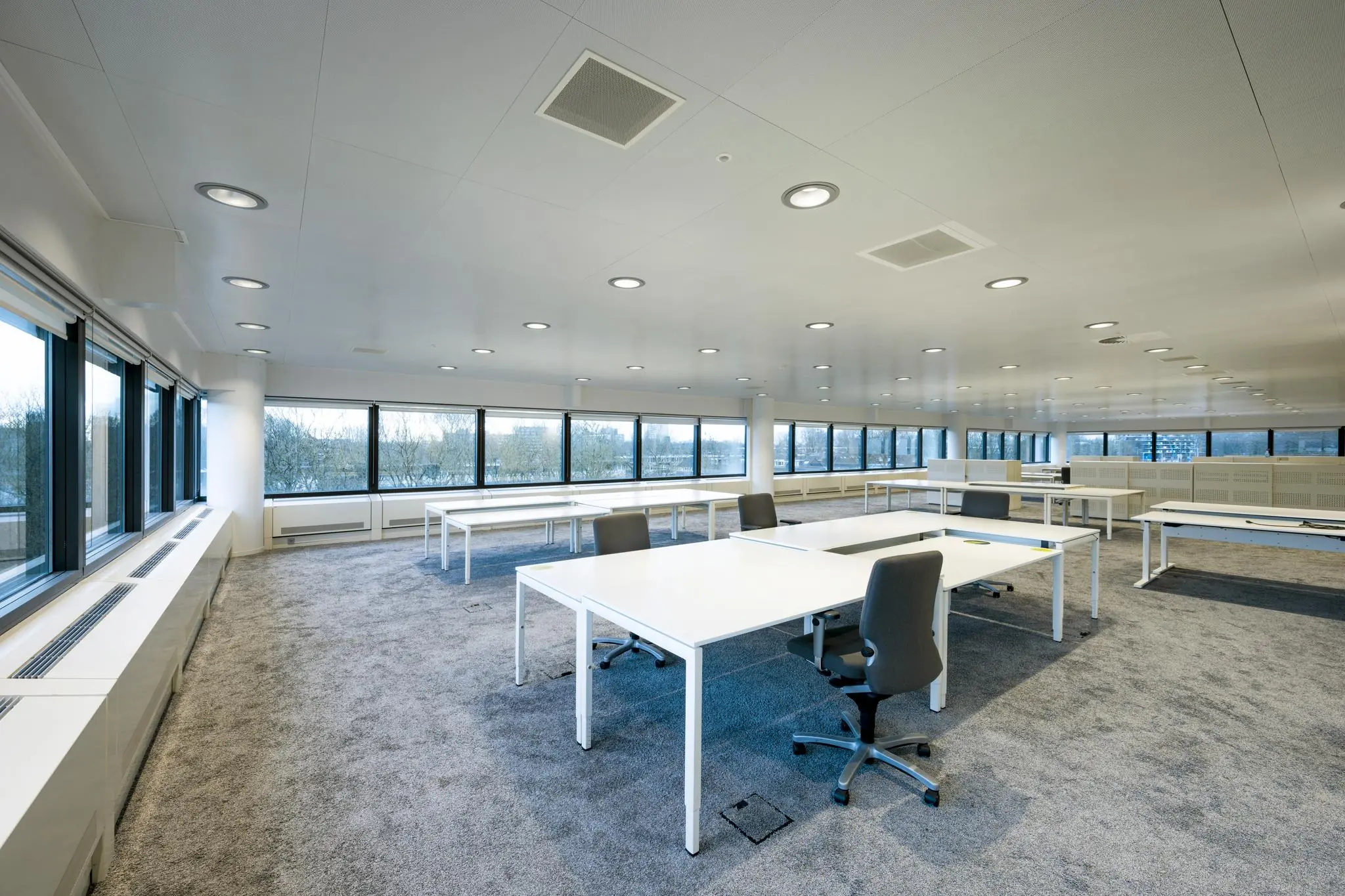 Ruim en modern kantoorinterieur aan de Prof. E.M. Meijerslaan met grote ramen en witte bureaus.