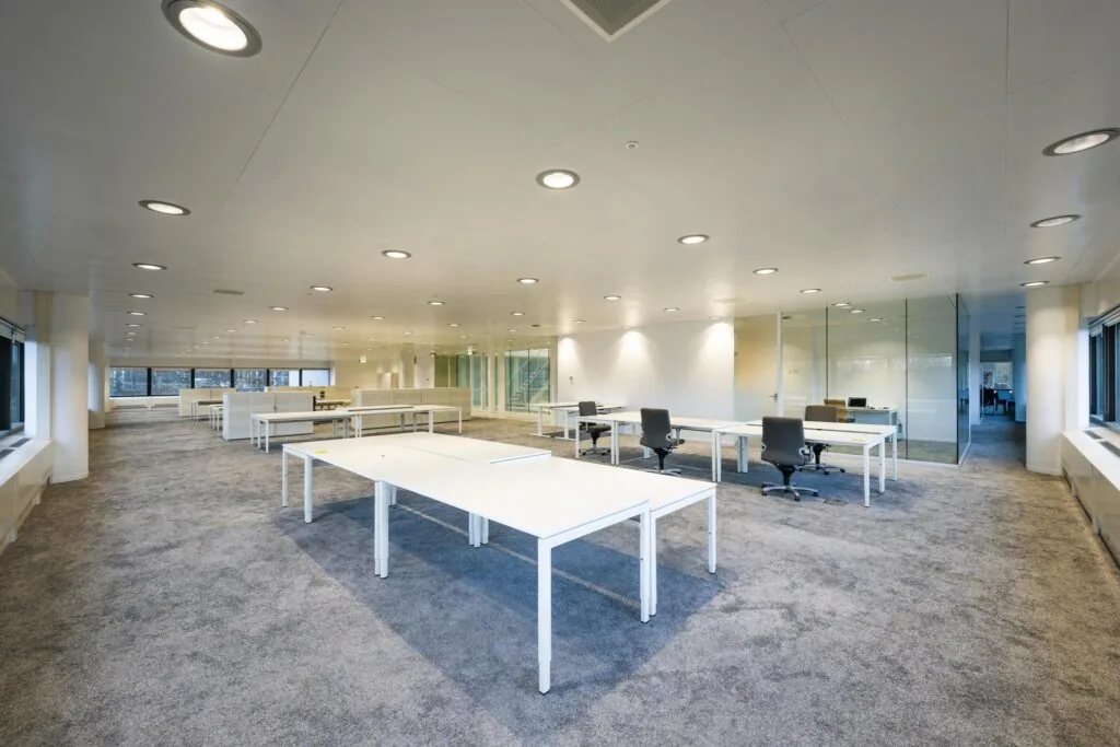 Moderne, open kantoorruimte aan de Prof. E.M. Meijerslaan met witte bureaus, grijze stoelen en glazen wanden.