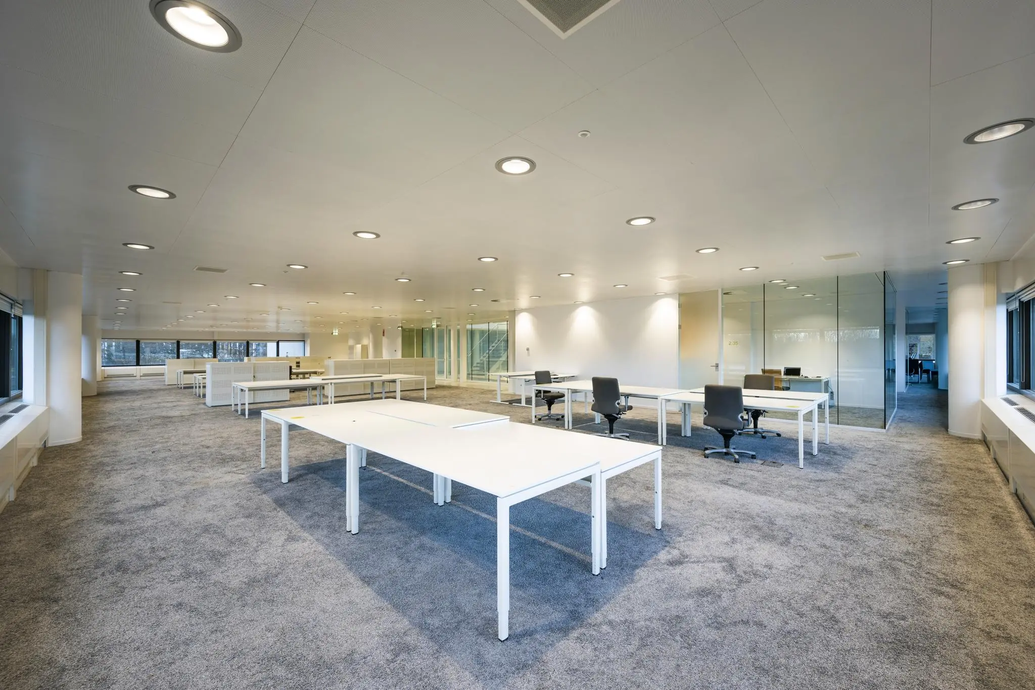Moderne, open kantoorruimte aan de Prof. E.M. Meijerslaan met witte bureaus, grijze stoelen en glazen wanden.