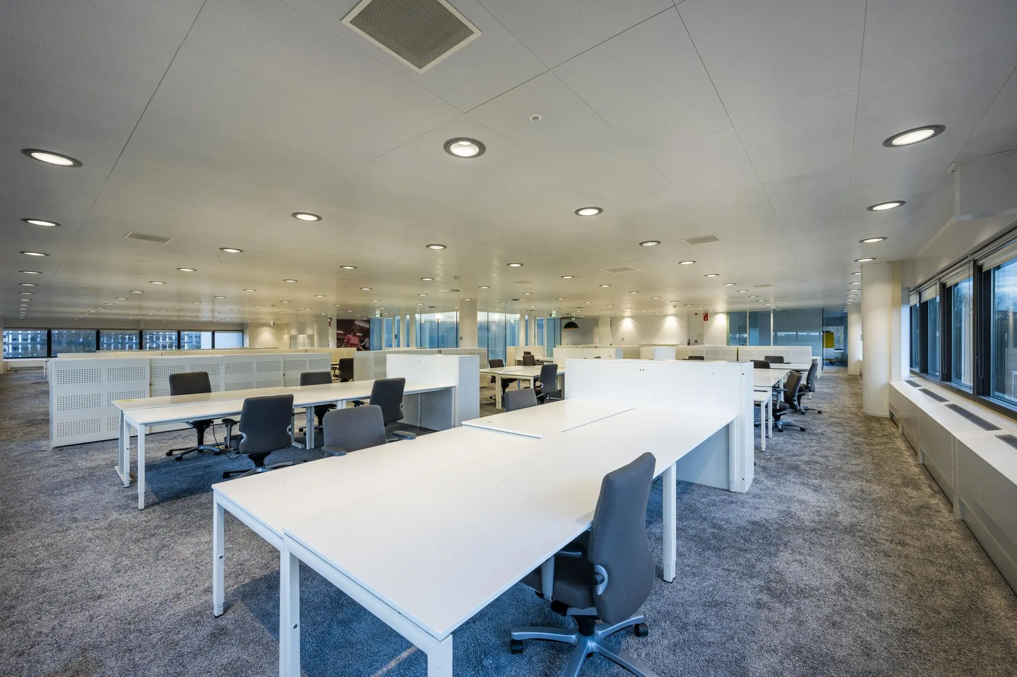 Moderne open kantoorruimte aan de Prof. E.M. Meijerslaan met witte bureaus, grijze stoelen en grote ramen.