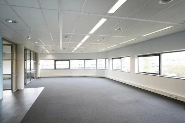 Licht, leeg kantoorruimte met grote ramen in kantoorgebouw Rietlandpark.