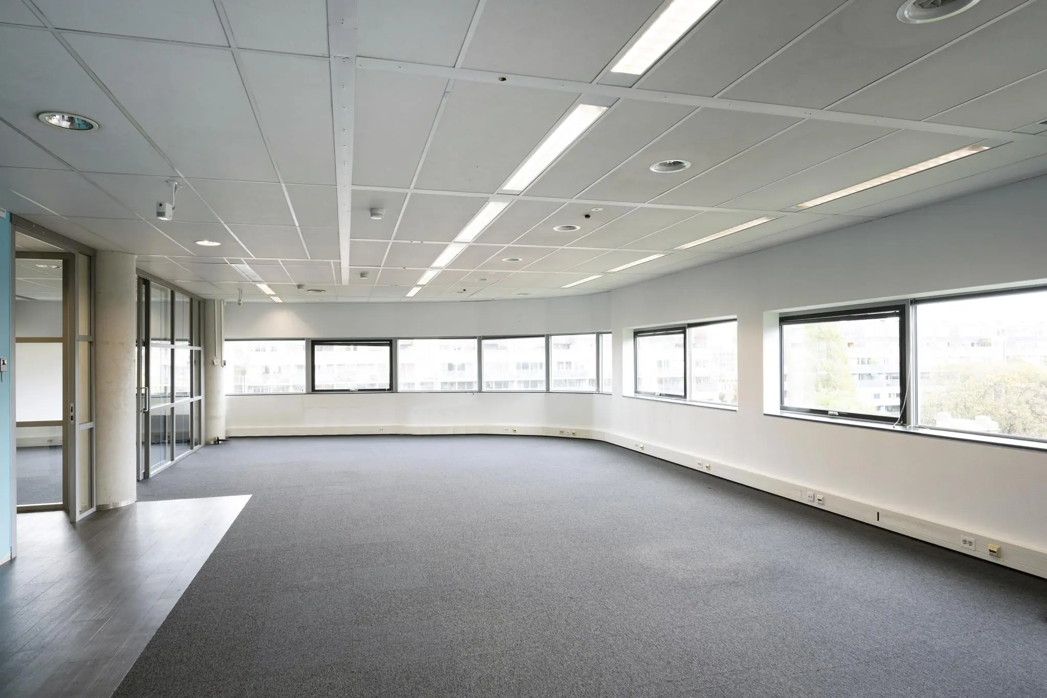 Licht, leeg kantoorruimte met grote ramen in kantoorgebouw Rietlandpark.