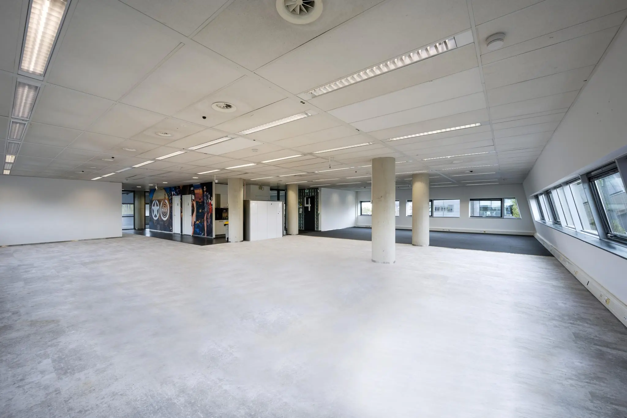 Licht en ruim leeg kantoorpand aan het Rietlandpark met grote ramen en systeemplafond.