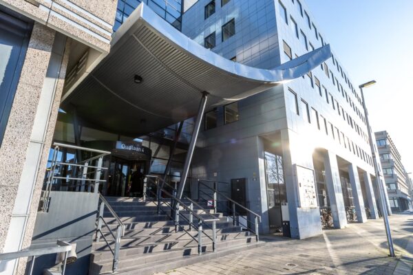 Entree van het moderne kantoorgebouw aan de Oudlaan 4 in Rotterdam met trap en gebogen luifel.