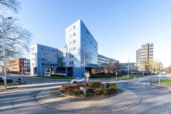 Modern kantoorgebouw aan de Oudlaan in Rotterdam met rotonde en sculptuur op de voorgrond.