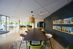 Moderne en lichte ontvangstruimte met een lange vergadertafel, tijdschriftenrek en uitzicht op de straat bij Hogehilweg.