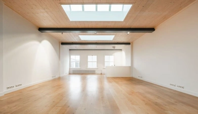 Licht en modern appartement aan de Keizersgracht met houten vloer, dakramen en witte muren.