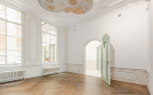 Lichte, klassieke kamer aan de Keizersgracht met visgraatvloer, grote ramen en een plafondschildering.