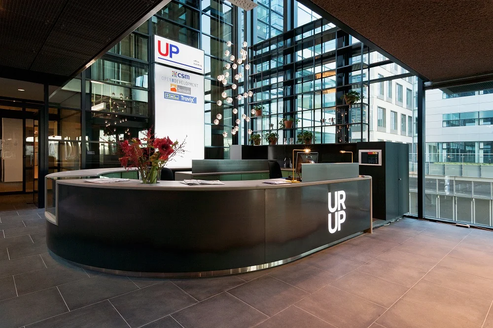 Moderne receptiebalie met het logo "UR UP" in een glazen kantoor aan de Piet Heinkade.