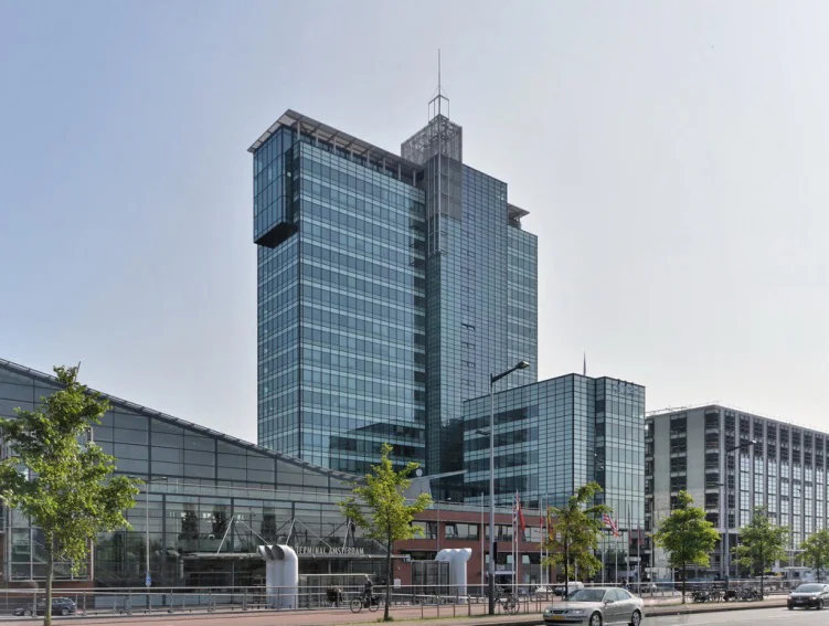 Glazen kantoorgebouw aan de Piet Heinkade in Amsterdam met moderne architectuur en omliggende stadsbebouwing.
