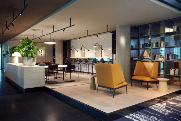 Moderne en sfeervolle lounge- en werkruimte aan de Piet Heinkade met designmeubilair, planten en open boekenkasten.