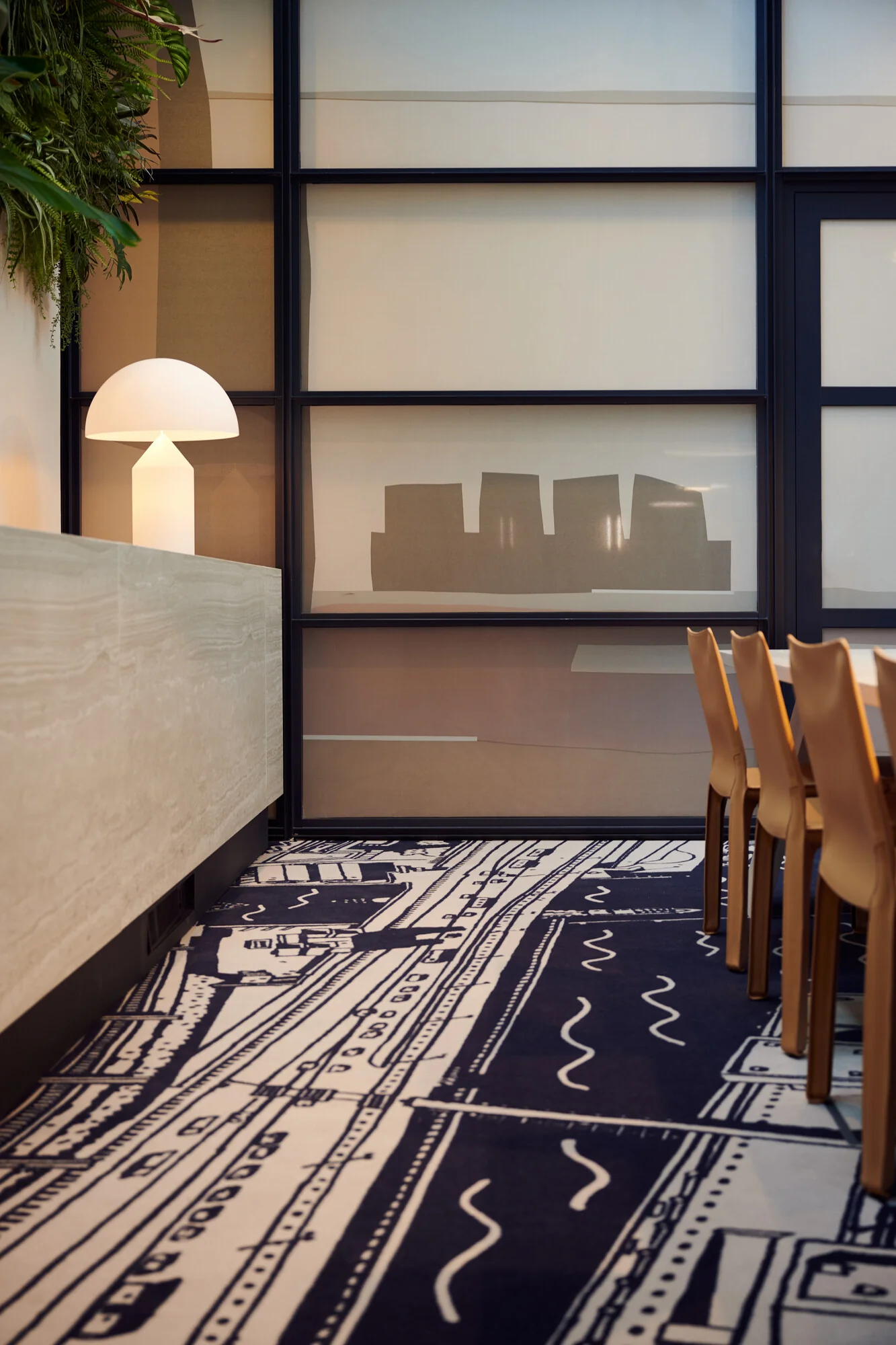 Moderne vergaderruimte aan de Piet Heinkade met designmeubilair, een opvallend grafisch tapijt en sfeervolle verlichting.