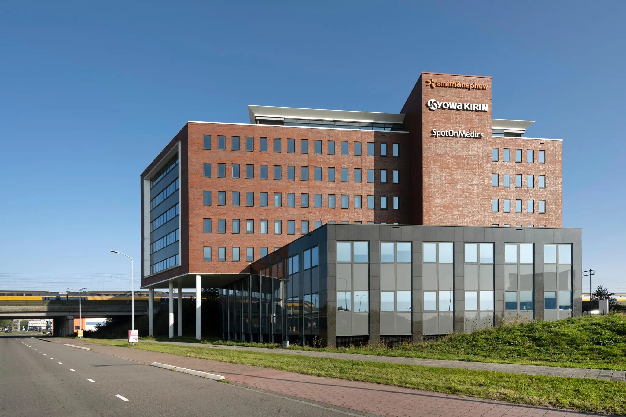 Modern kantoorgebouw aan de Bloemlaan met logo's van Smith & Nephew, Kyowa Kirin en SpotOnMedics op de gevel.