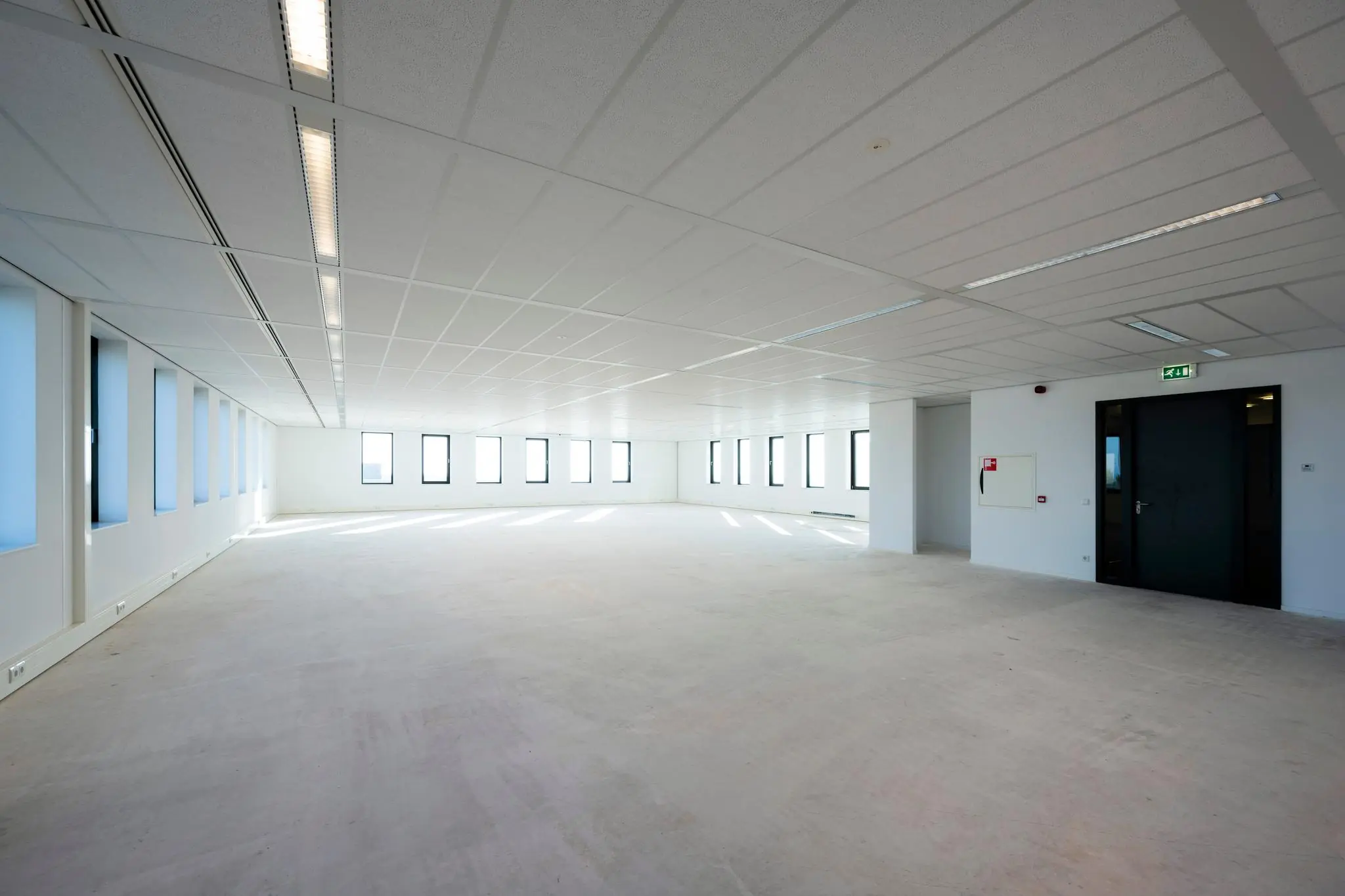 Leeg, licht en ruim kantoorpand aan de Bloemlaan met grote ramen en systeemplafond.