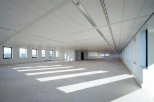 Licht en ruim leeg kantoorpand aan de Bloemlaan met grote ramen en systeemplafond.