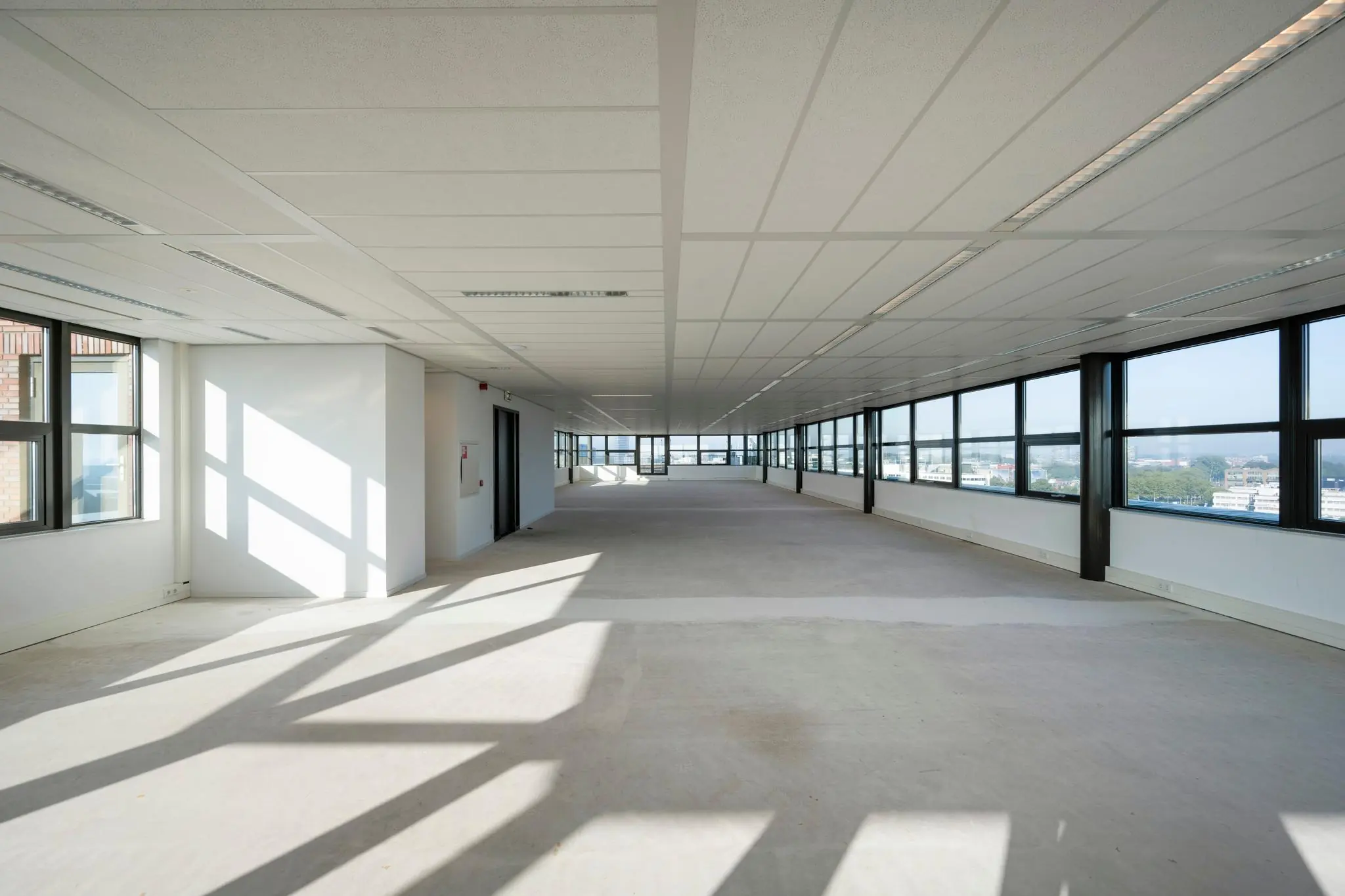 Licht en ruim leeg kantoor met grote ramen aan de Bloemlaan.