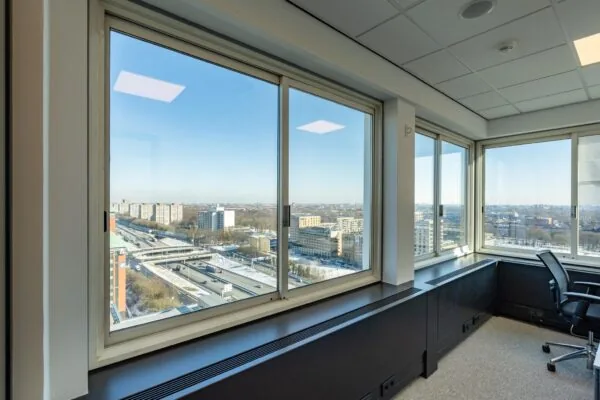 Uitzicht vanuit een kantoorruimte aan het Koningin Wilhelminaplein op een snelweg en omliggende hoogbouw in Amsterdam.