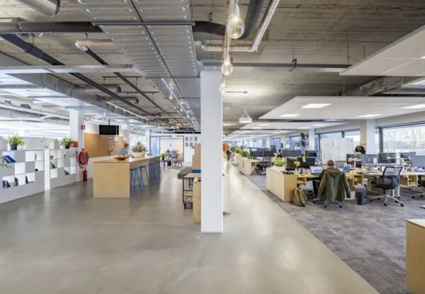 Moderne en ruime kantoortuin aan de Joan Muyskenweg met open werkplekken en een informele ontmoetingsruimte.